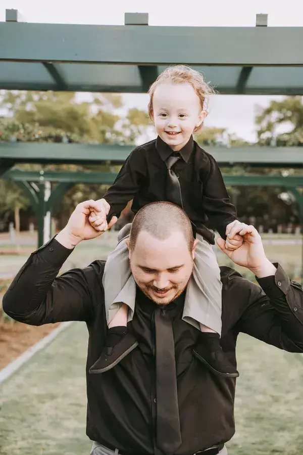 Child sitting on a parent's shoulders during a family session