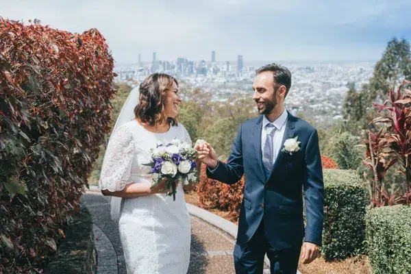Bride and groom walking above the Brisbane skyline